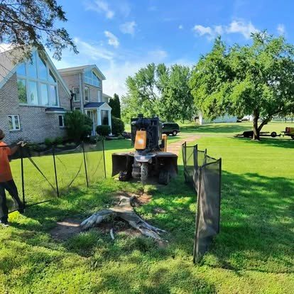 Triple B's grinding a stump with protective fencing set up to shield a Central Indiana home